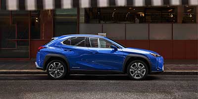 blue BEV sits parked on the street.