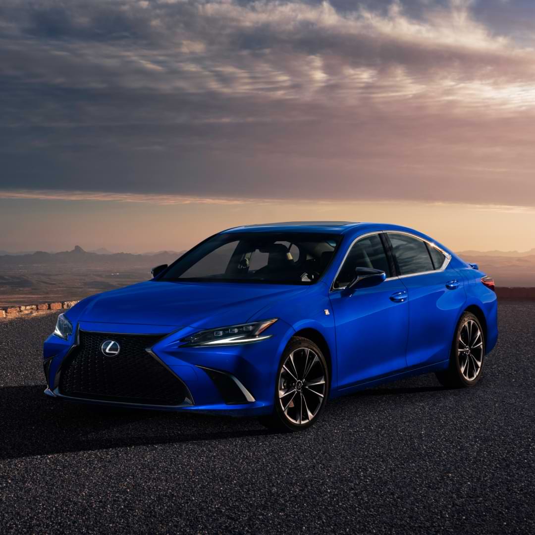 Front view of a blue 2021 ES. It is parked on pavement in a light pink sunset.