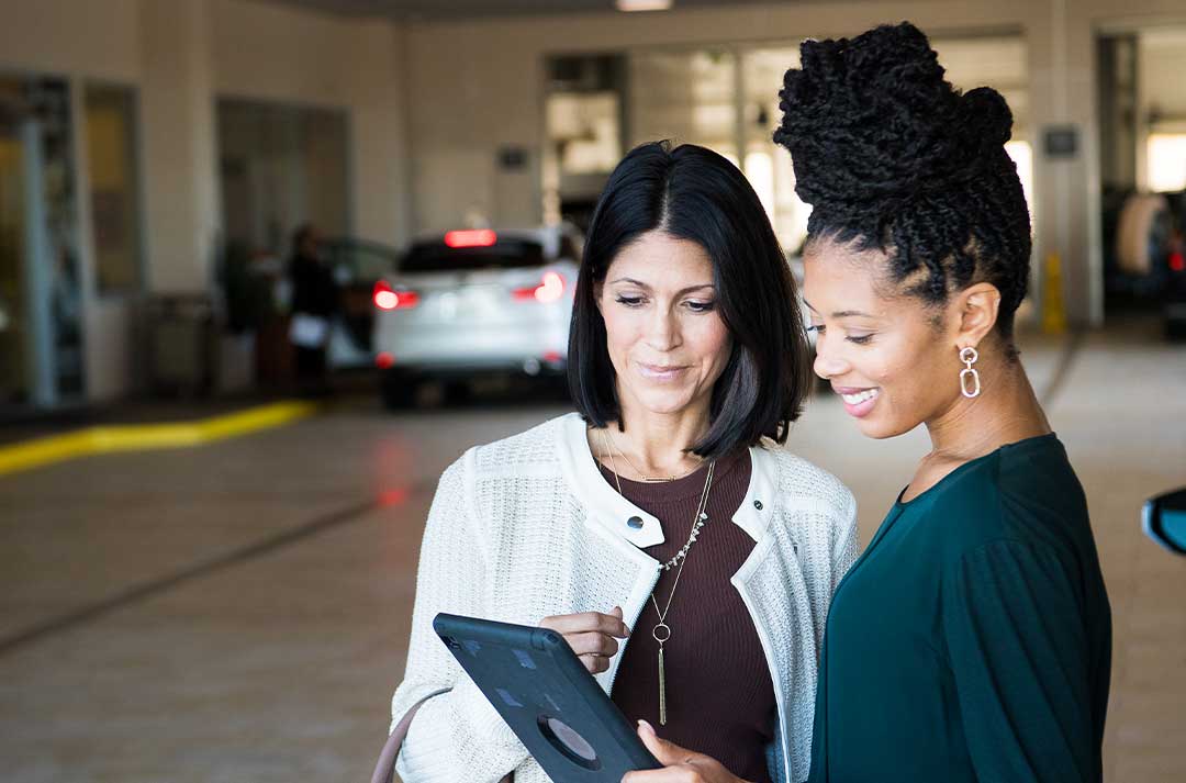 Two women are consulting over an ipad