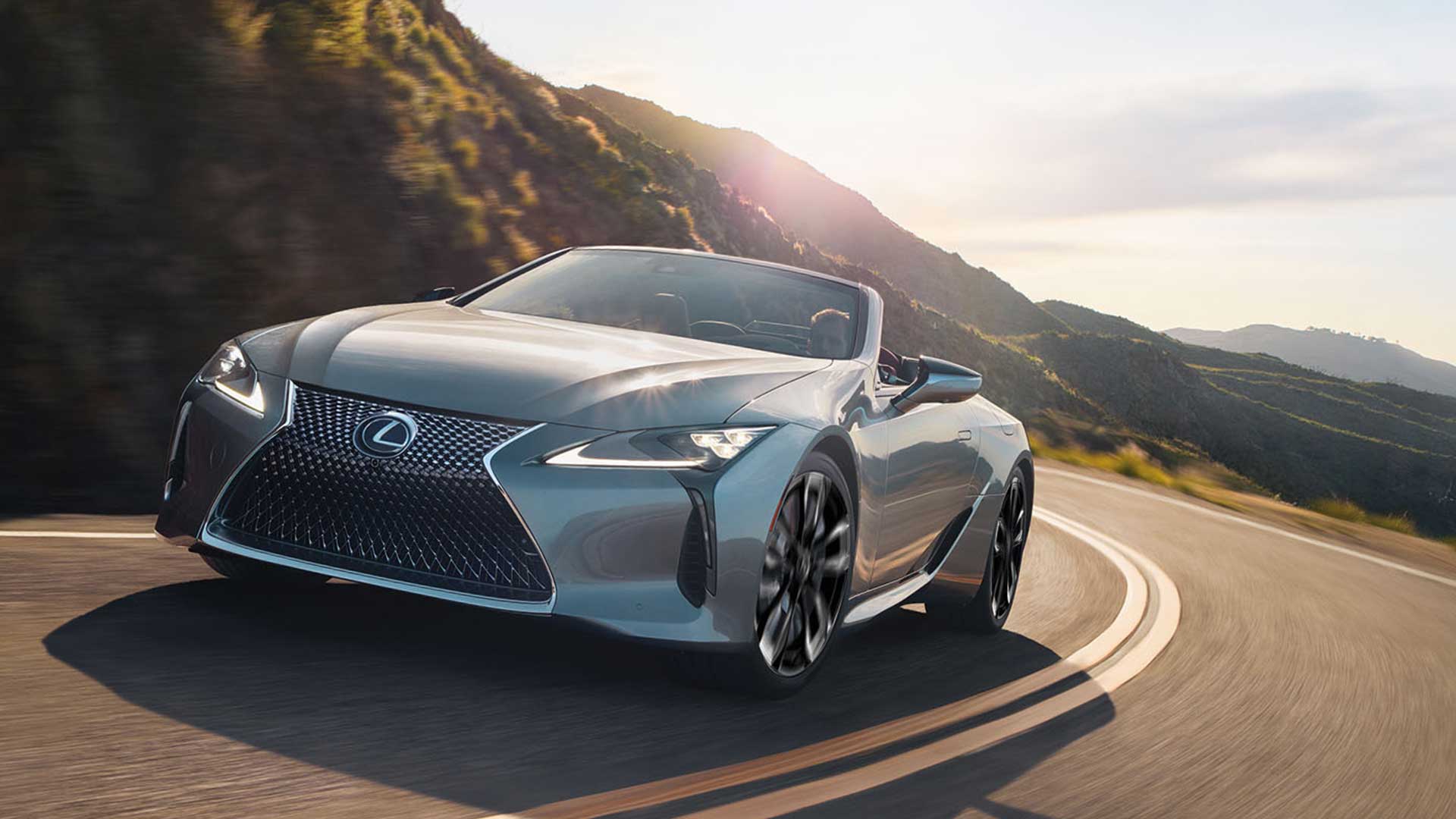 A white LC 500 Convertible drives up a curving mountain road.